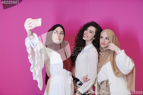 Image of muslim women taking selfie picture isolated on pink