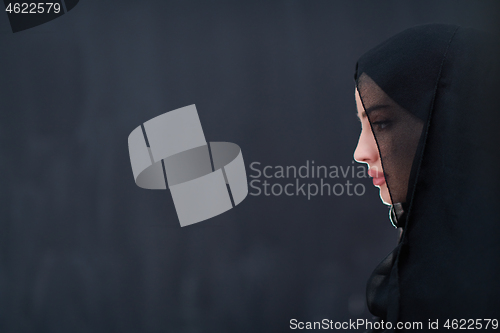 Image of portrait of beautiful muslim woman in front of black chalkboard