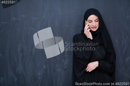 Image of young modern muslim business woman using smartphone