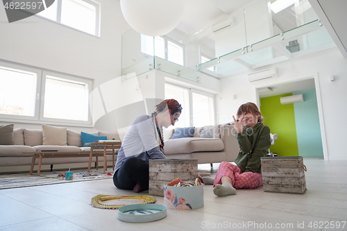 Image of Mother and little girl daughter playing with jewelry  at home