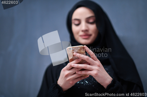 Image of young modern muslim business woman using smartphone