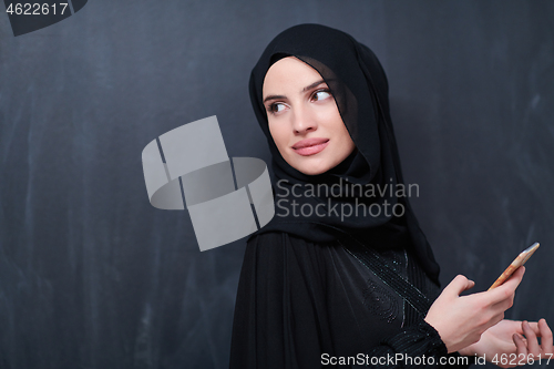 Image of young modern muslim business woman using smartphone