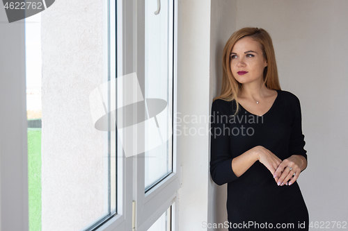 Image of Beautiful girl looks in a new apartment in a new building