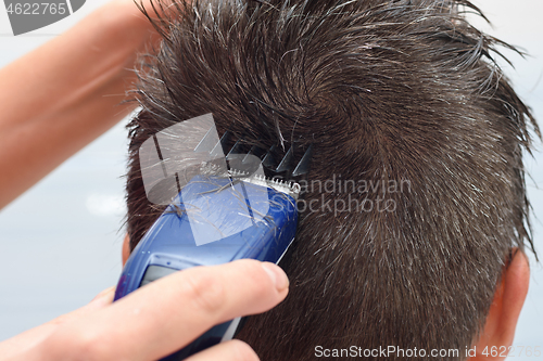 Image of Hairdresser cuts the hair on the top of the head, close-up