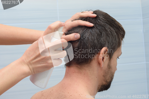 Image of Hairdresser dampens hair before cutting at home