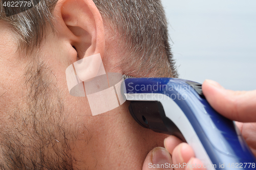 Image of Hairdresser straightens hair on a man\'s neck