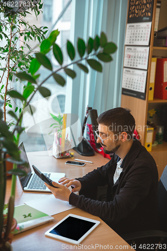 Image of Caucasian entrepreneur, businessman, manager working concentrated in office