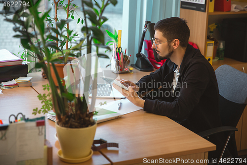 Image of Caucasian entrepreneur, businessman, manager working concentrated in office