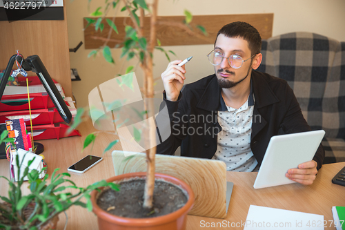 Image of Caucasian entrepreneur, businessman, manager working concentrated in office