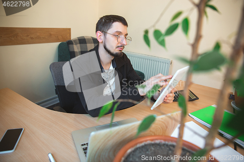 Image of Caucasian entrepreneur, businessman, manager working concentrated in office