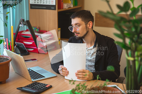 Image of Caucasian entrepreneur, businessman, manager working concentrated in office