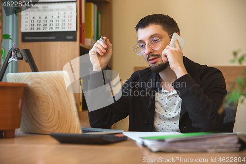 Image of Caucasian entrepreneur, businessman, manager working concentrated in office