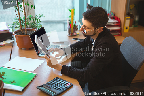 Image of Caucasian entrepreneur, businessman, manager working concentrated in office