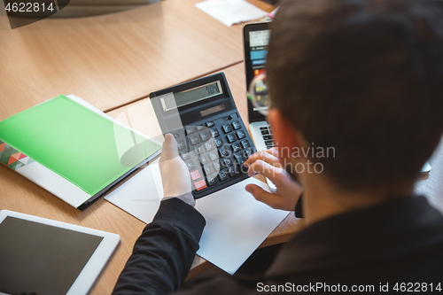 Image of Caucasian entrepreneur, businessman, manager working concentrated in office