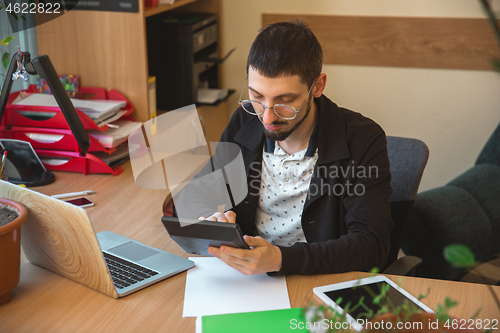 Image of Caucasian entrepreneur, businessman, manager working concentrated in office