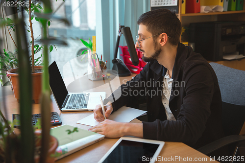 Image of Caucasian entrepreneur, businessman, manager working concentrated in office