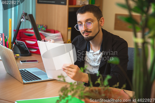 Image of Caucasian entrepreneur, businessman, manager working concentrated in office