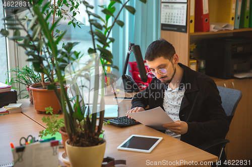 Image of Caucasian entrepreneur, businessman, manager working concentrated in office