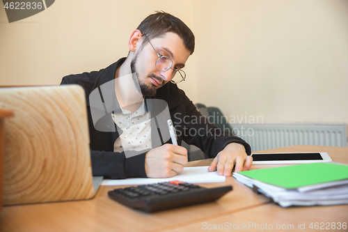 Image of Caucasian entrepreneur, businessman, manager working concentrated in office