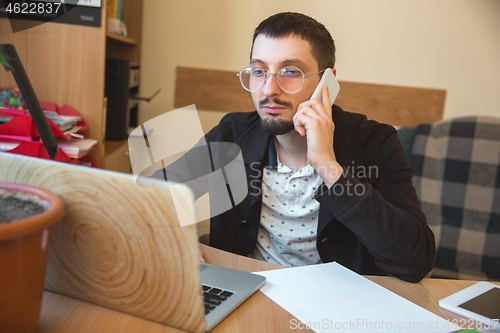 Image of Caucasian entrepreneur, businessman, manager working concentrated in office