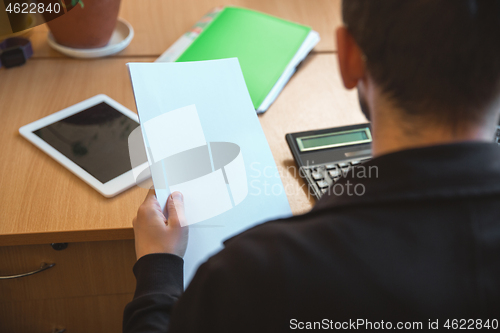 Image of Caucasian entrepreneur, businessman, manager working concentrated in office