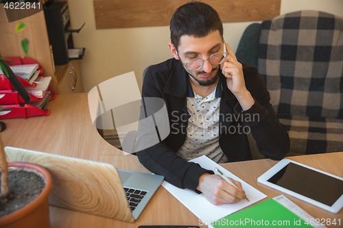 Image of Caucasian entrepreneur, businessman, manager working concentrated in office