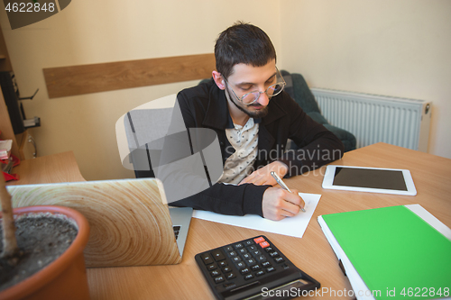 Image of Caucasian entrepreneur, businessman, manager working concentrated in office