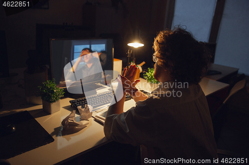 Image of Man working in office alone during coronavirus or COVID-19 quarantine, staying to late night