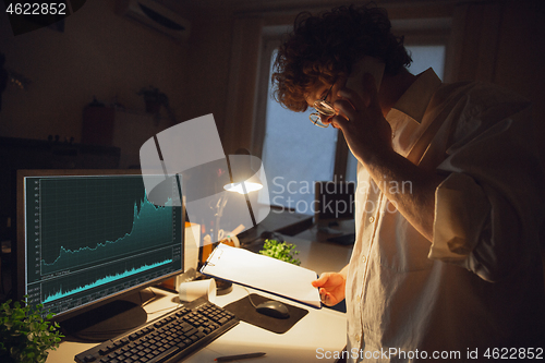 Image of Man working in office alone during coronavirus or COVID-19 quarantine, staying to late night