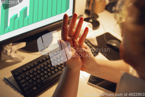 Image of Man working in office alone during coronavirus or COVID-19 quarantine, staying to late night