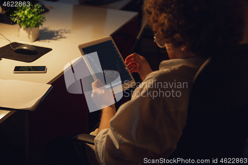 Image of Man working in office alone during coronavirus or COVID-19 quarantine, staying to late night