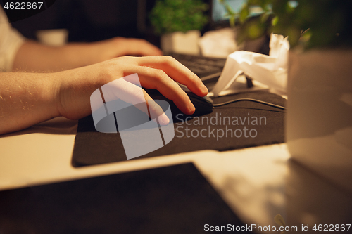 Image of Man working in office alone during coronavirus or COVID-19 quarantine, staying to late night