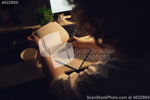 Image of Man working in office alone during coronavirus or COVID-19 quarantine, staying to late night