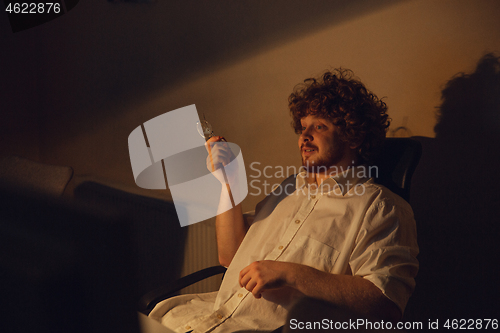 Image of Man working in office alone during coronavirus or COVID-19 quarantine, staying to late night