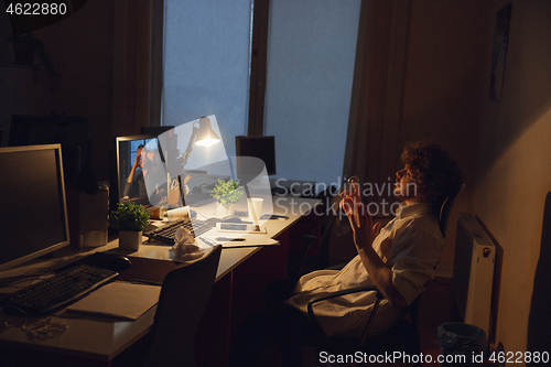 Image of Man working in office alone during coronavirus or COVID-19 quarantine, staying to late night