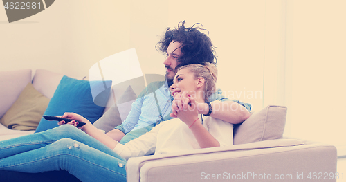 Image of Young couple on the sofa watching television