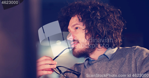 Image of man working on computer in dark office