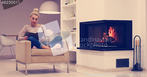 Image of beautiful woman at home reading book