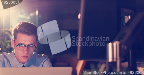 Image of man working on computer in dark office