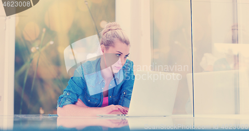 Image of young women using laptop computer on the floor