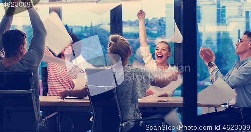 Image of multiethnic Group of young business people throwing documents