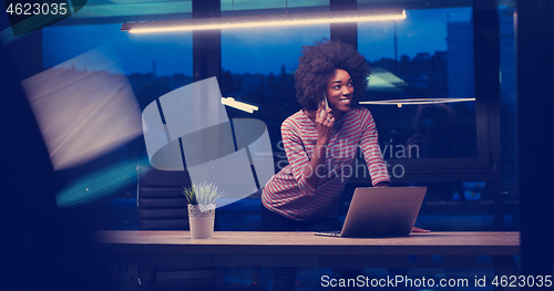 Image of black businesswoman using a laptop in night startup office