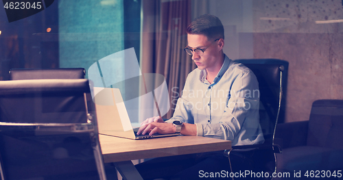 Image of man working on laptop in dark office