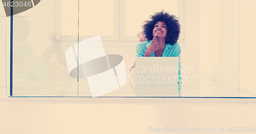 Image of black women using laptop computer on the floor