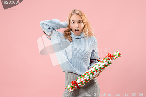 Image of Woman with big beautiful smile holding colorful gift box.