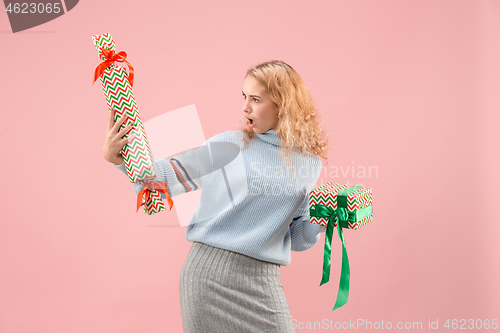 Image of Woman with big beautiful smile holding colorful gift boxes.