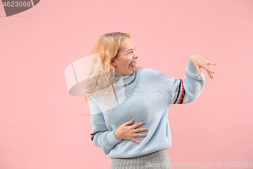 Image of The happy business woman standing and smiling against pink background.