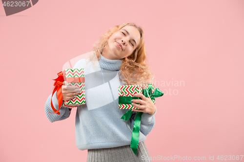 Image of Woman with big beautiful smile holding colorful gift boxes.