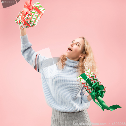 Image of Woman with big beautiful smile holding colorful gift boxes.