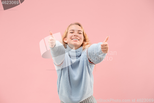 Image of The happy business woman standing and smiling against pink background.